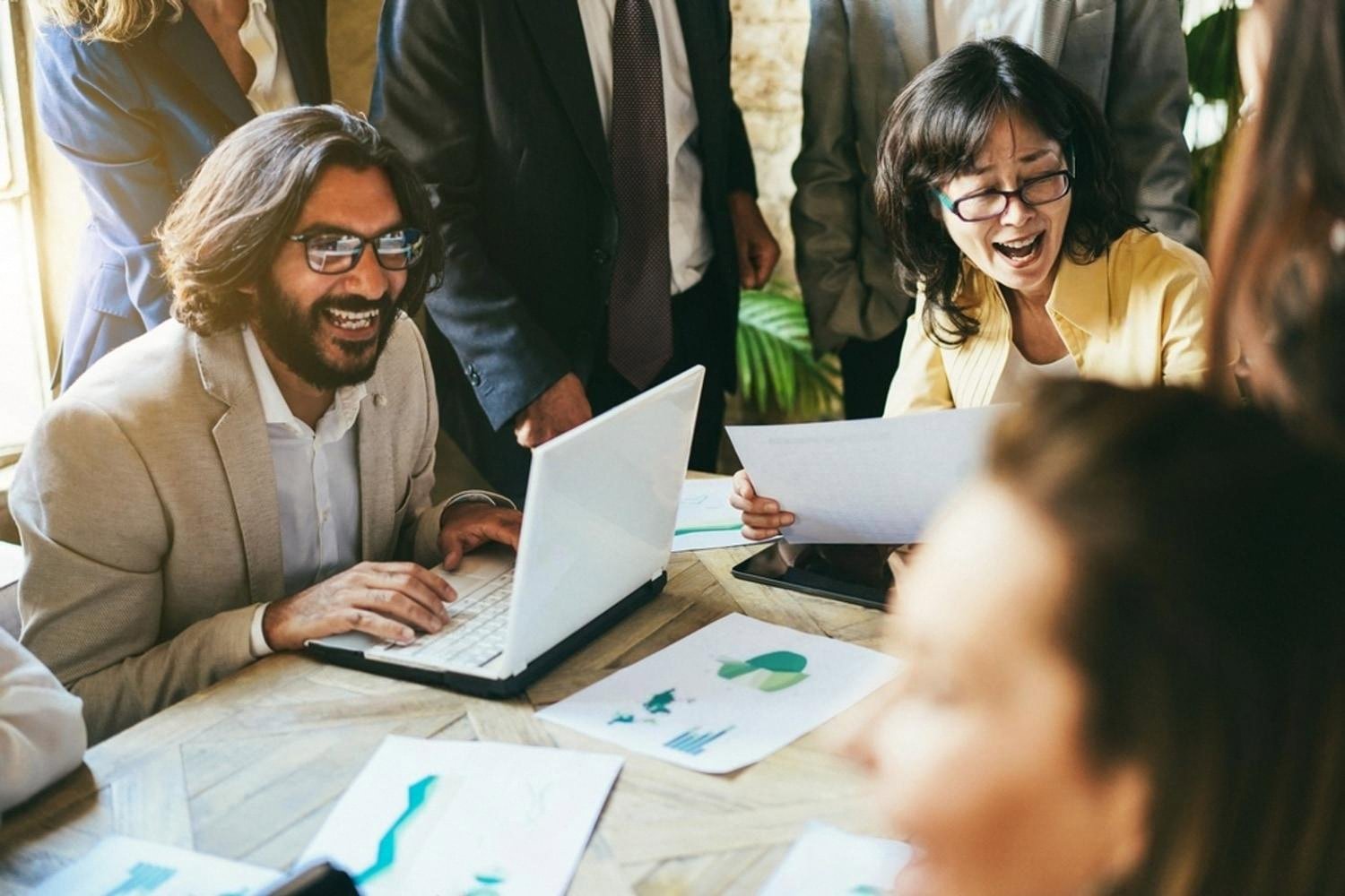 Engaged team members laughing during a workplace meeting in the UAE